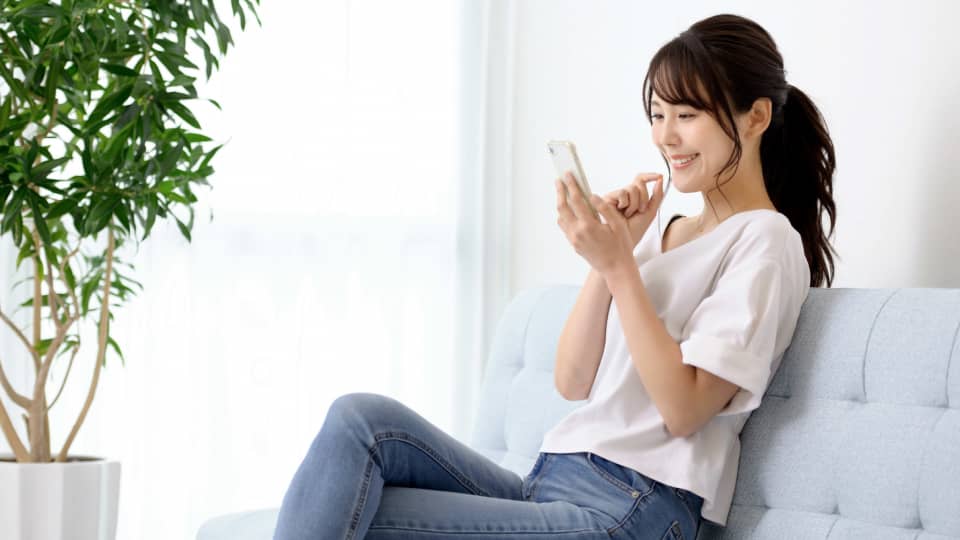 スマホを見ながら笑顔を見せる女性